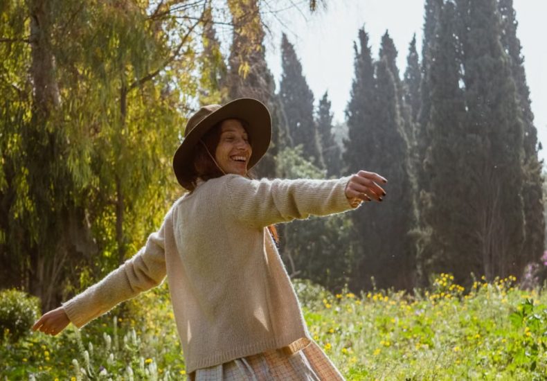 A carefree woman in a sunlit garden, enjoying nature and freedom.